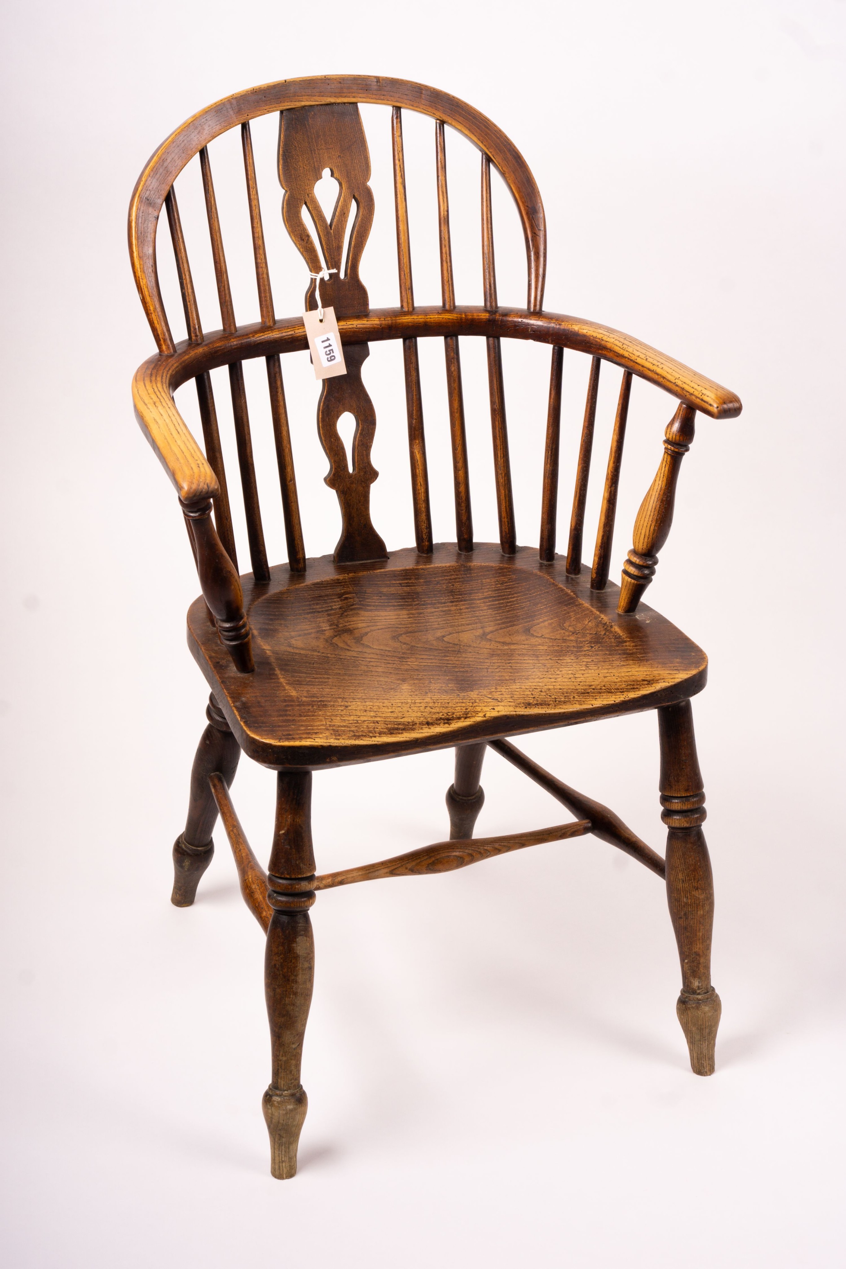 A mid 19th century ash and elm Derbyshire area Windsor elbow chair, together with a 19th century yew and elm Windsor wheel back chair with crinoline stretcher